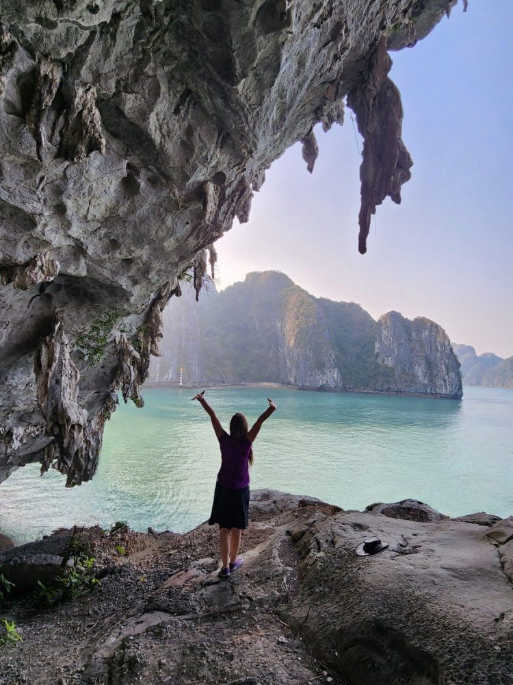 Woman raising her arms in victory at Halong Bay