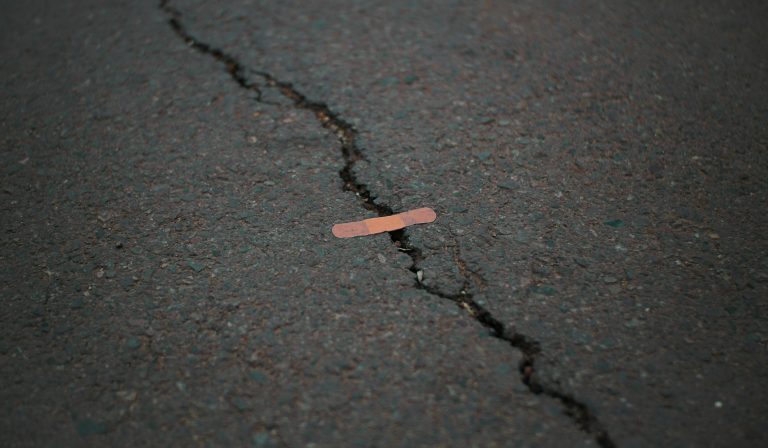 Small band-aid on a large crack on pavement